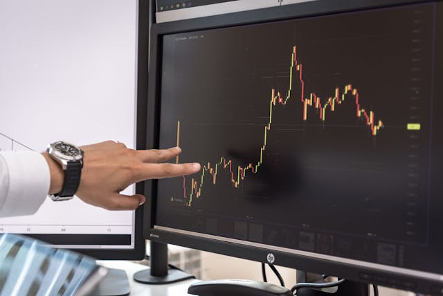 main-sur-ecran-avec-graphique-cryptomonnaie